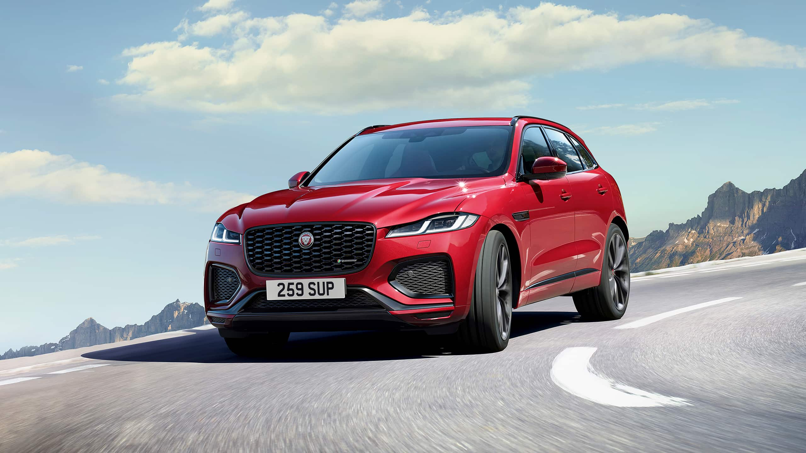  Jaguar F-PACE car moving on hill road with cloudy and covered with mountains